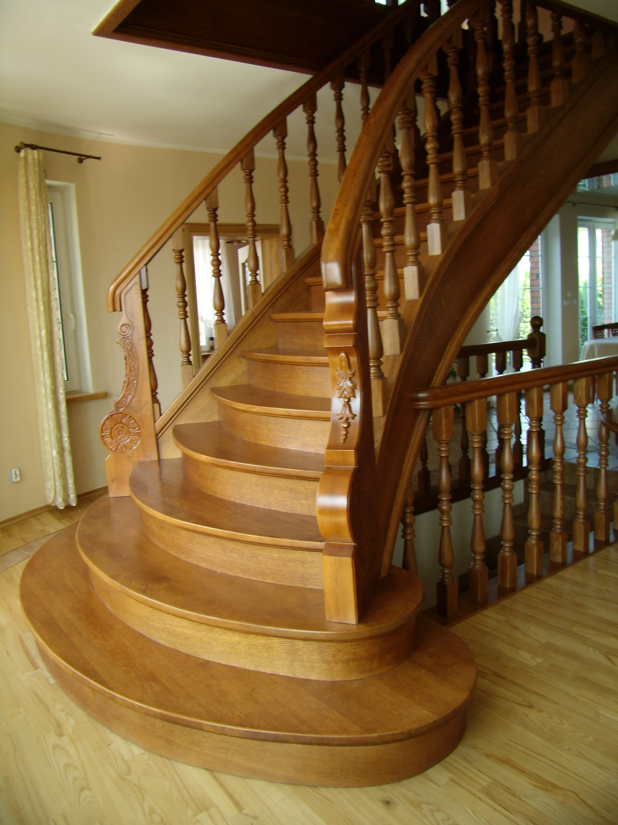 Detal rzeźbionej balustrady i giętych policzków dębowych