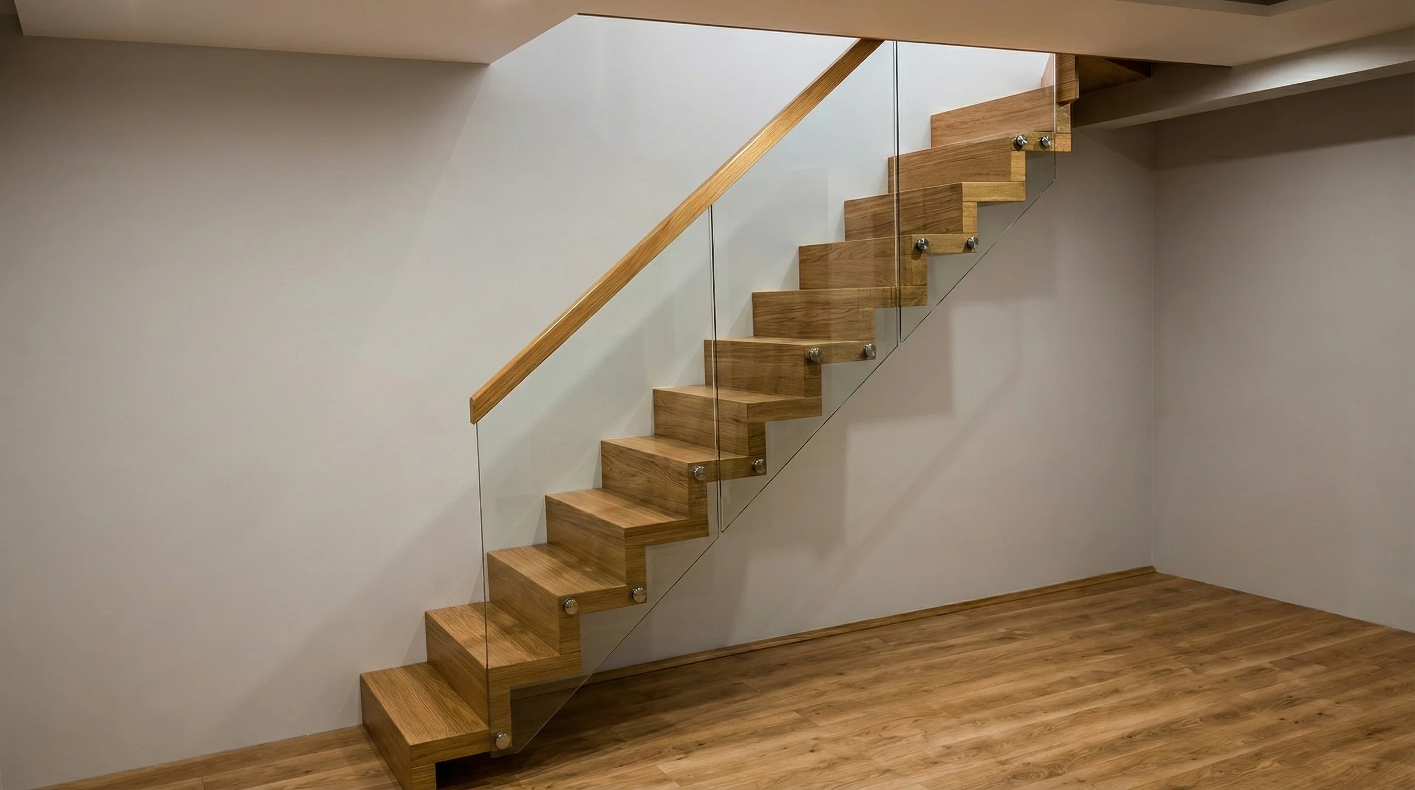 Detal drewnianych stopni jesionowych i szklanej balustrady