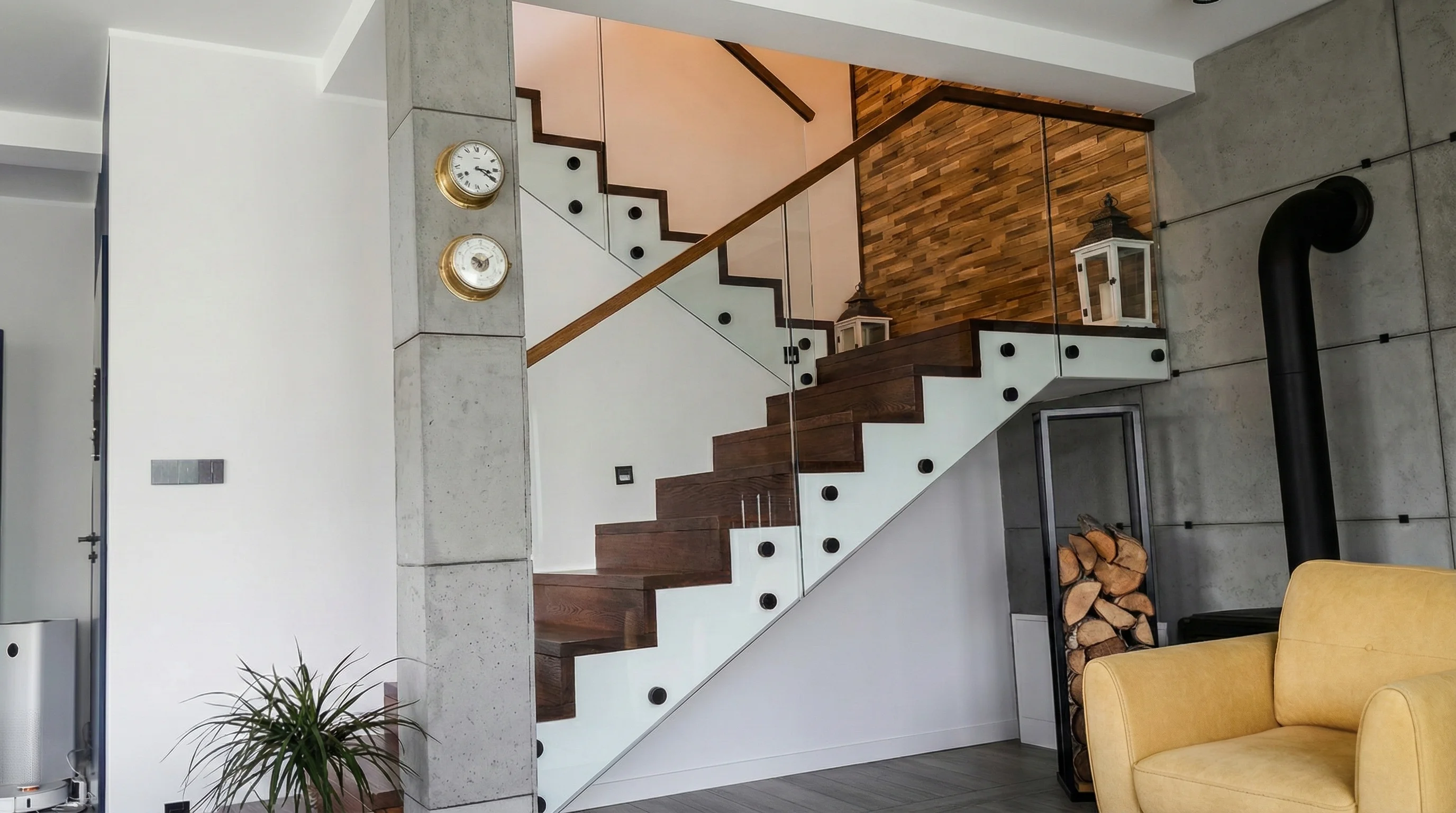 Detal szklanej balustrady samonośnej przy szczotkowanych stopniach dębowych