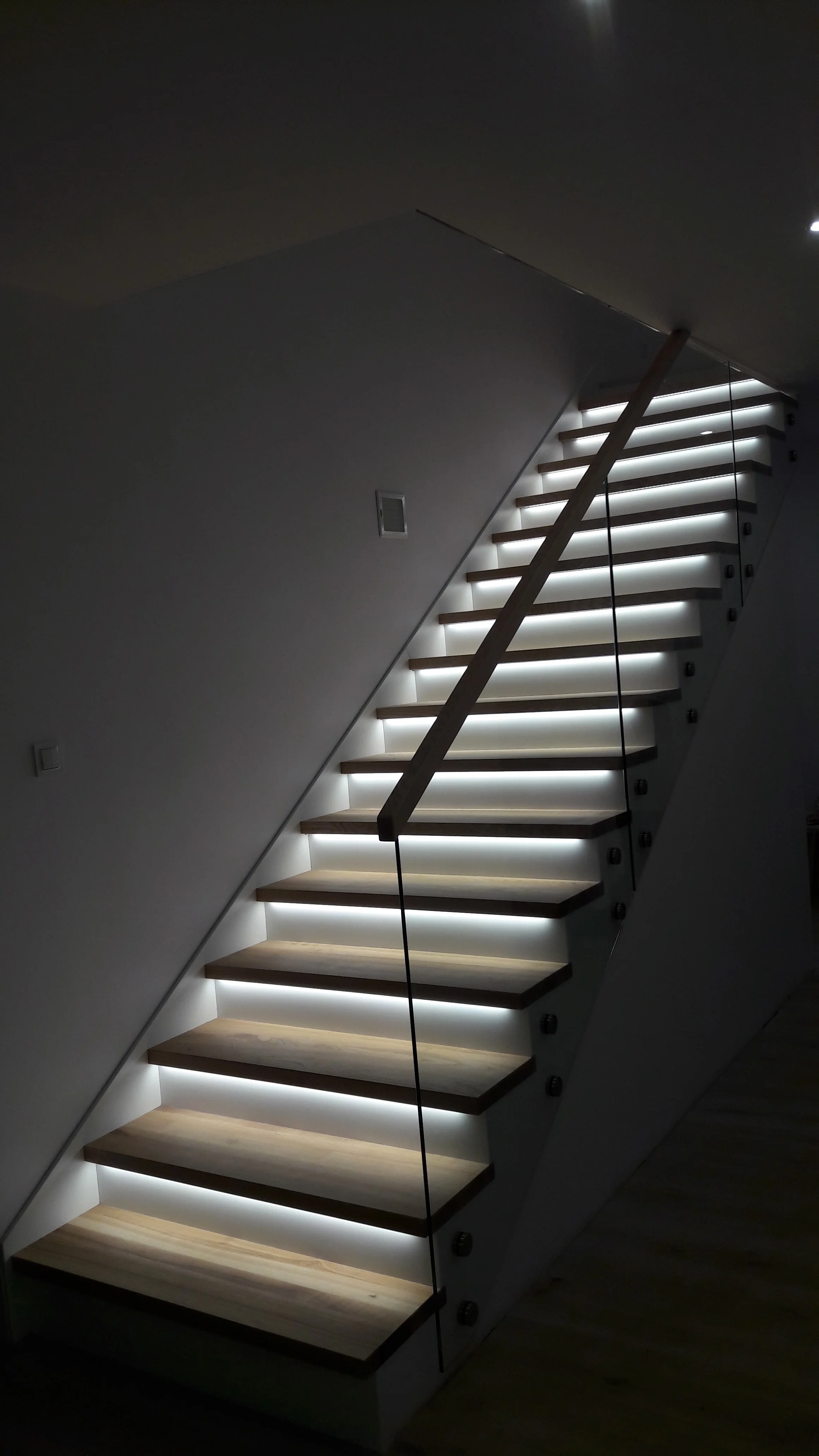 Białe podstopnice i jesionowe stopnie, nowoczesne schody wewnętrzne