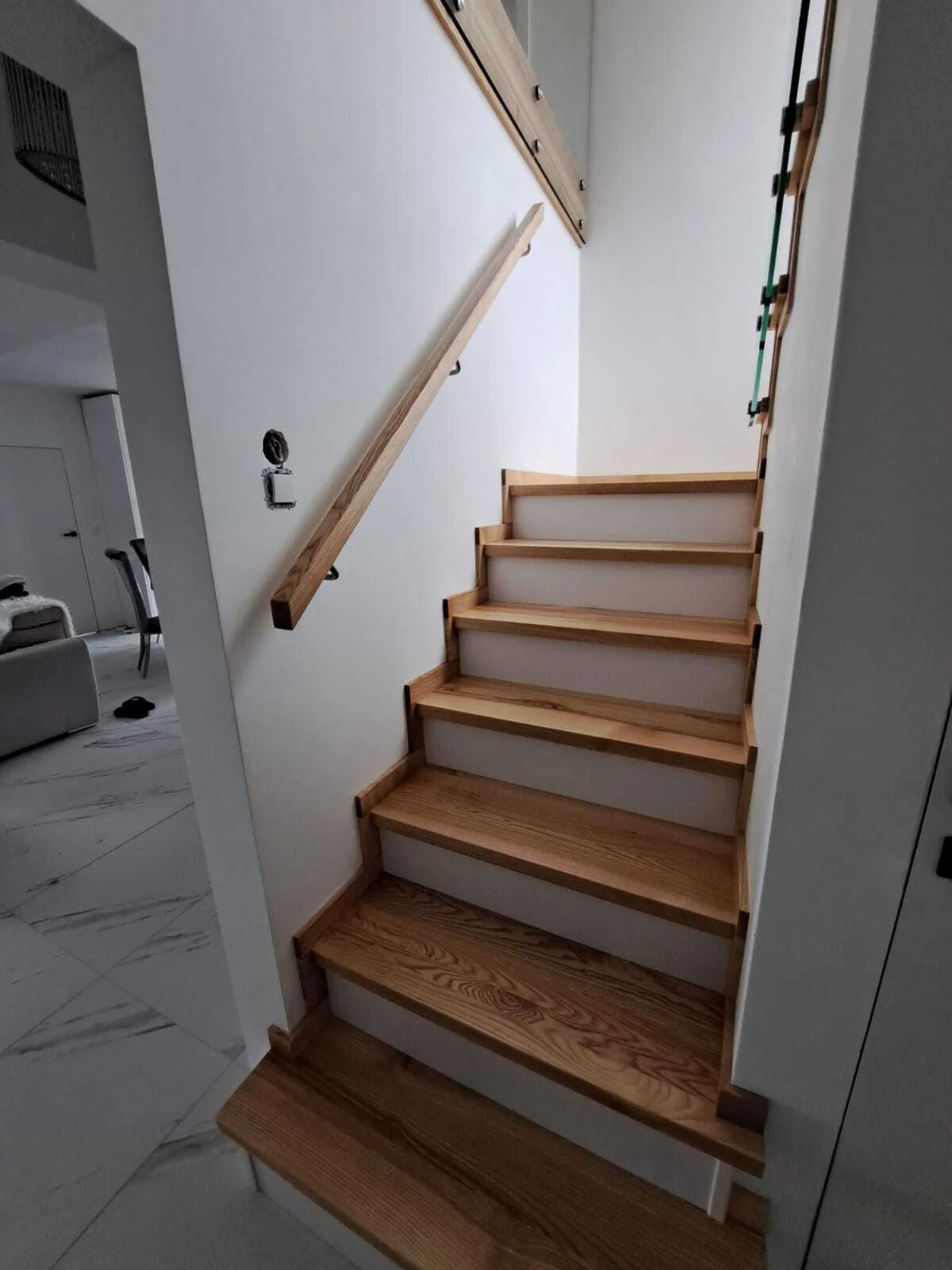 Nowoczesne wnętrze ze schodami jesionowymi i szkłem